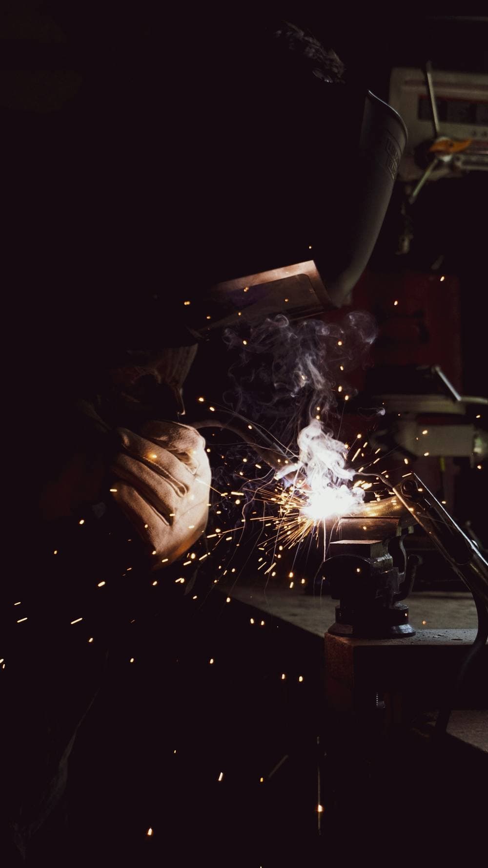 Field welder working on heavy equipment outdoors